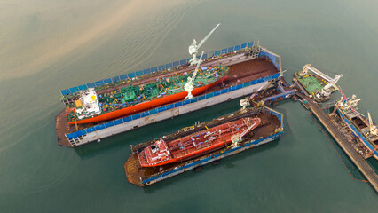 cargo container ship at dry dock concept maintenance service working in the sea. Insurance and...