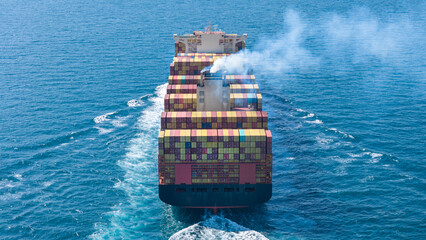 Aerial stern view of cargo ship carrying container and running for export goods from cargo yard...