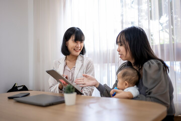 Obraz premium A woman is talking to another woman and a baby