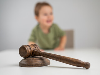 Little boy behind judge's gavel. 