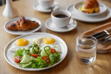 Delicious breakfast served on wooden table in cafe, closeup