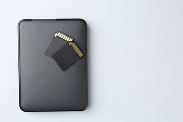 External hard drive and SD memory cards on white background, top view. Space for text