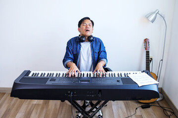 Portrait of Professional Pianist Enjoying And Playing On Electric Piano At Home Studio