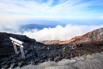  Hikers Descending Mount Fuji with Torii Gate and Clouds