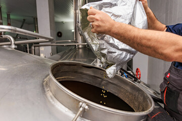 Brewing process: adding ingredients to steel kettle