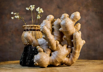 big and beautiful ginger root and wicker basket with flower on dark background, close-up