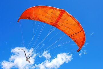 A vibrant orange parachute soars against a clear blue sky, capturing the thrill of adventure and the beauty of outdoor sports.