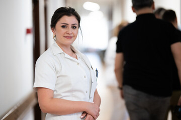 A tired nurse takes a quiet moment to rest in the hospital hallway, reflecting on a long and...