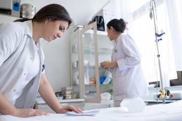 Obraz premium Two nurses in a hospital laboratory are carefully inspecting and preparing medications for patients and hospital use.