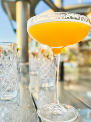 Alcohol cocktail drink French Blonde in a martini glass on the table in the restaurant outdoors.