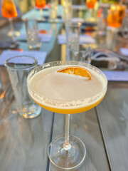 Alcohol cocktail drink French Blonde in a martini glass on the table in the restaurant outdoors.