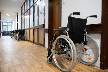A row of wheelchairs neatly lined up in a hospital corridor, ready for patients in need of mobility assistance