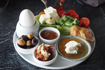  turkish breakfast spread features vegetables, cheese, and olives on a plate