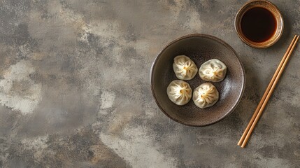 Chinese dumplings in a rustic bowl, soy sauce on the side, and chopsticks perfectly poised for use.
