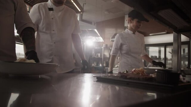 Man chef grating parmesan cheese into plate on kitchen platform