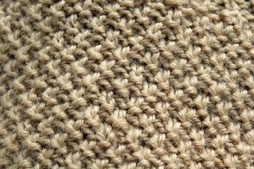 Beige woven knitted crocheted wool fabric material close-up abstract textured background