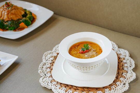 Fish lip soup in white bowl with herbs and spices on top with Herbal Infusion