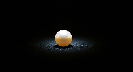 Obraz premium Single Pearl Glowing on Black Surface with Shimmering Light Spot
