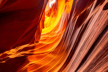 This natural wonder in the USA, Antelope Canyon, Arizona, features swirling sandstone patterns. Rays of sunlight accentuate its unique shapes and breathtaking color palette.