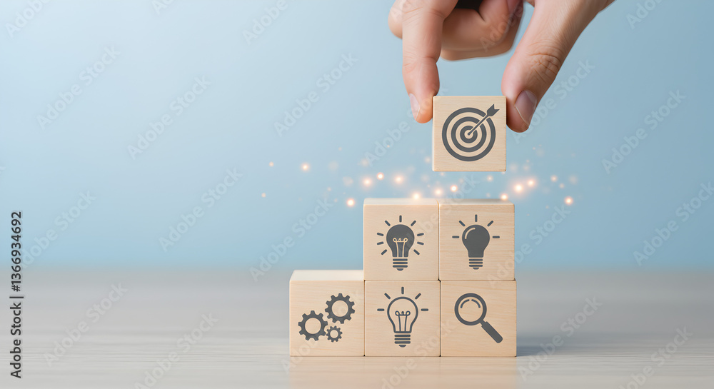 Poster hand placing target icon block on stacked blocks with light bulb and gear icons on wooden table agai