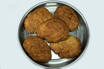A plate of crispy, golden brown Thekua, a popular sweet snack from Bihar and Jharkhand, made from wheat flour, jaggery, and ghee. Often prepared during Chhath Puja.