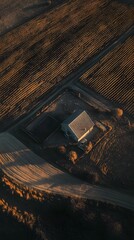 Fototapeta premium Aerial view of a picturesque farmhouse nestled in a lush rolling field of crops bathed in the warm glow of the sun and enhanced by contemporary cinematic lighting