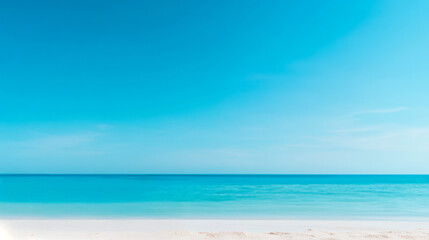 Obraz premium A tranquil beach scene featuring a clear blue sky and calm turquoise waters meeting a soft sandy shore.