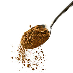 Brown powder on a spoon spilling onto black background,