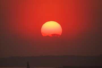 Obraz premium スギ花粉の飛散が始まっていて、太陽の周りに花粉光環が現れている。 ちなみに八丈島は亜熱帯のため杉が自生しておらず、かつ本土から300kmほど離れているので、花粉が飛ぶことはない。 東京湾から眺める美しい夕陽。 東海汽船東京湾～伊豆諸島八丈島、太平洋航路の橘丸船上-2025 