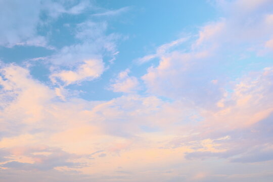 Soft pastel colors fill the sky as clouds drift gently during sunset, painting a tranquil scene that evokes peace and calmness in the early evening light.