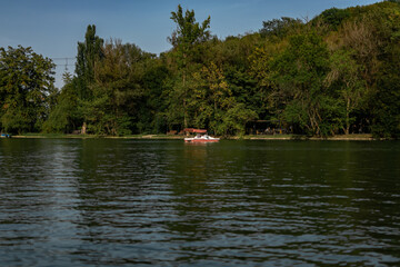 organization of leisure and recreation in summer. a walking and entertainment area by the lake shore with catamarans and cafes. a picturesque beach with trees and shrubs