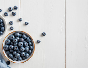 Blueberry fruits. Group of fresh organic blueberries in a bowl on a white wooden table. Healthy and vegetarian food. Directly above. Copy space.