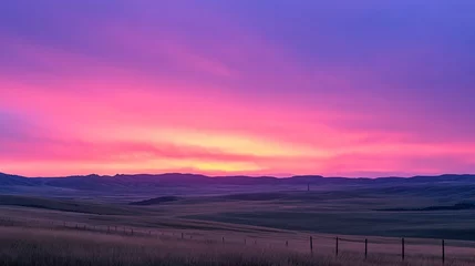Gordijnen Vibrant pink and purple sunrise over a vast, flat prairie landscape with a distant mountain range. © BerkahStock