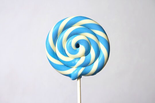 A photo of a lollipop with a swirled blue and white design - Powered by Adobe