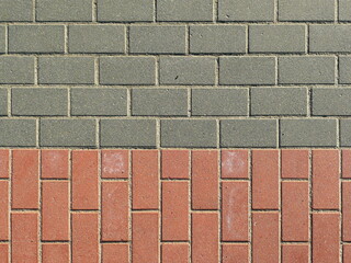 Gray and red rectangular concrete paving as a traffic area for pedestrians and cyclists creates a stable, durable, textured surface. Space for text