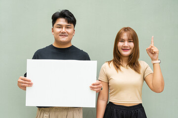 young Asian couple holding blank board
