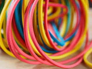 Close-up of multi-colored elastic bands showing off vibrant hues and texture, perfect for office.