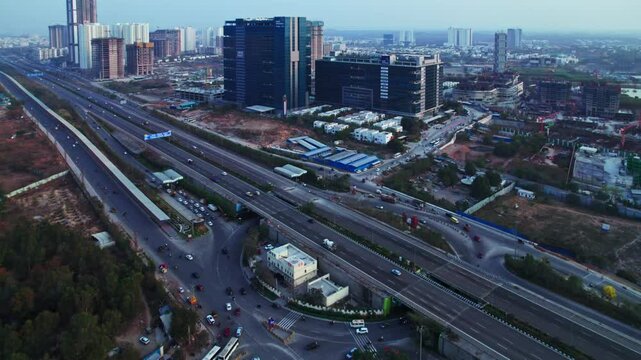 Hyderabad Outer ring road with financial district circle and glass facade building at ORR Exit 1, nanakramguda, financial district, hyderabad, telangana, india. day time, push in, drone shot, 4k.