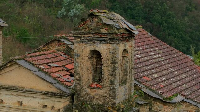 Aerial view of the damaged roof of the Church of Pigna San Michele Arcangelo, showcasing the worn tiles and aging structure, with signs of decay and natural overgrowth. Historic site.