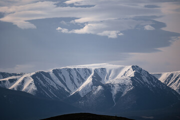 Majestic snow-capped mountain peaks under dramatic skies in Altai Siberia