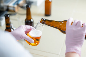 Craft beer production process in brewery lab with bottles and glassware