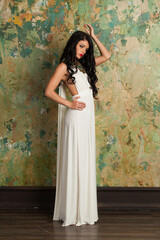Stylish fashion woman in white silk dress posing in perfect interior