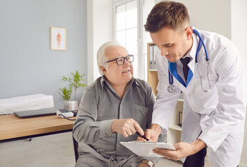 Senior patient man receives medical care during a hospital consultation. The dedicated doctor and...