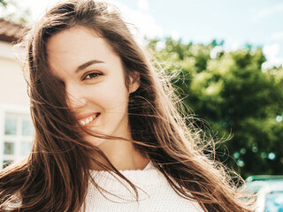Closeup portrait of beautiful smiling brunette model. Trendy female posing in the street...