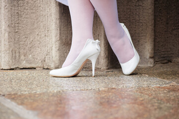 Woman's Feet in White High Heels on Urban Stone Surface