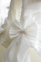 Elegant Close-Up of a Bridal Dress Featuring White Satin Bow Detail..
