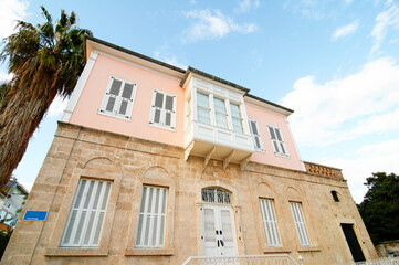 Elegant Two-Story Mediterranean House with Stone Facade and Wooden Shutters