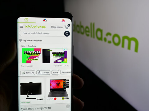 Stuttgart, Germany - 03-10-2025: Person holding web page with logo of Chilean retail company Falabella S.A. on screen in front of logo. Focus on center of phone display.