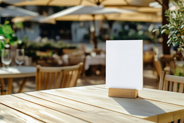 Empty vertical table card on a wooden table with blurred outdoor cafe background. Ideal for restaurant menus, event signage, or branding presentations