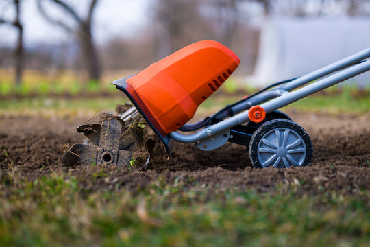 Garden tiller, rotary tiller, mini cultivator or rotavator. Tillers break up compacted soil, improve its structure and aeration. Preparing garden beds for planting.